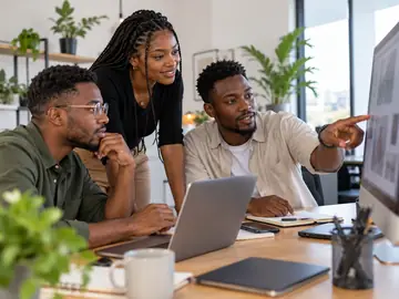Equipa de uma agência a rever um projeto num ecrã grande